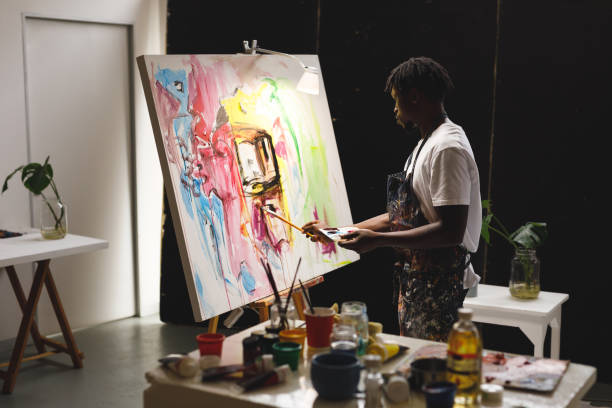 istock African american male painter at work painting on canvas in art studio 1332149454