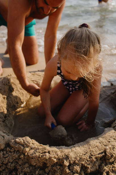 istock Brother and sister building a sandcastle on beach 1332149578