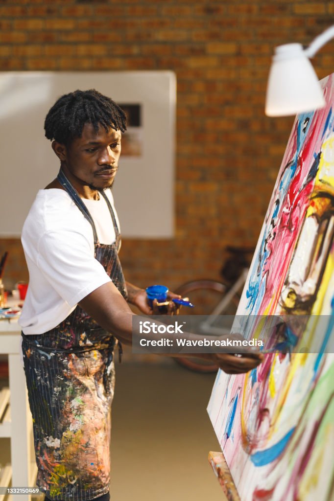 African American Male Painter At Work Painting On Canvas In Art Studio African American Male Painter At Work Painting On Canvas In Art Studio