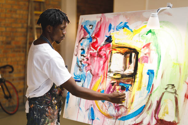 istock African american male painter at work painting on canvas in art studio 1332150619