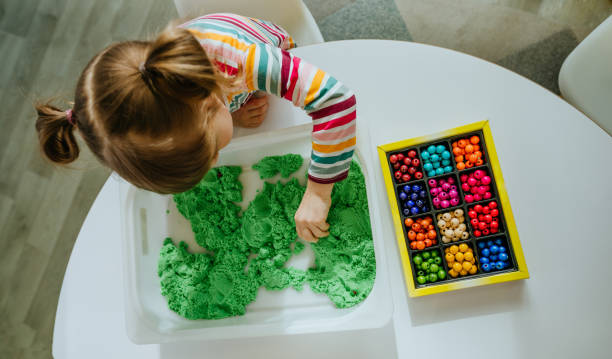 istock Preschool students playing with kinetic sand in kindergarten 1332150686