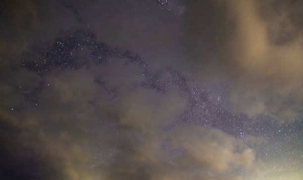 istock Starry sky and long exposhur clouds. Dark night sky with clouds. Astronomical background. 1332150962