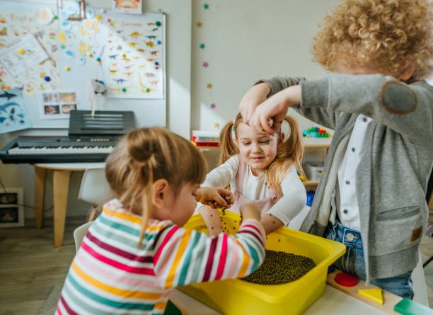 istock Preschool students playing with raw mung beans in kindergarten 1332150974