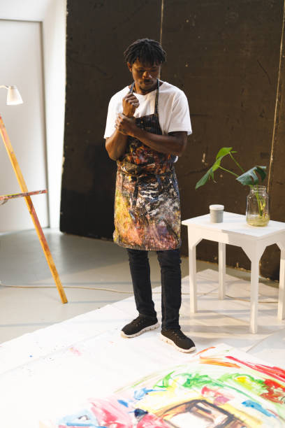 istock African american male painter at work looking at artwork in art studio 1332151020