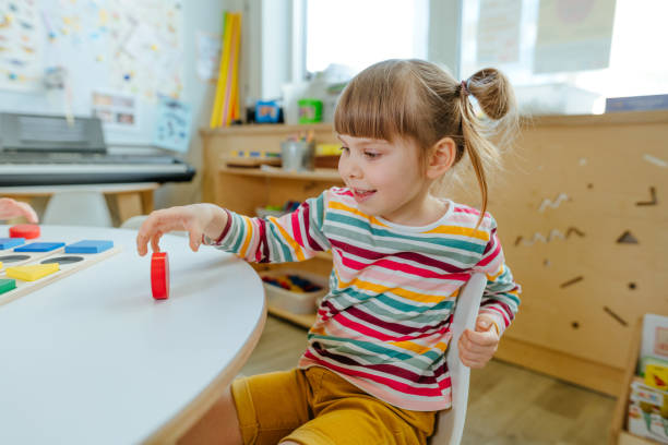 istock Adorable preschool student sorting wooden geometric forms 1332151056