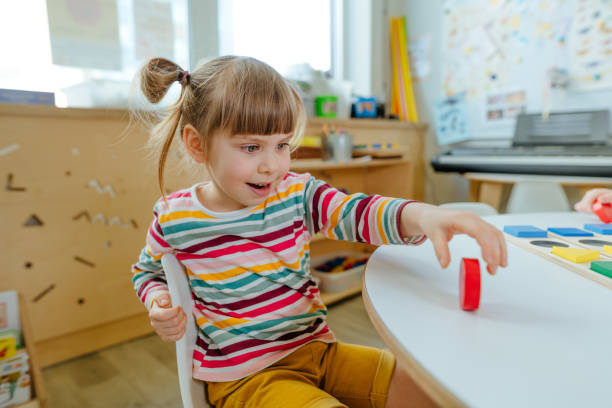 istock Adorable preschool student sorting wooden geometric forms 1332151062