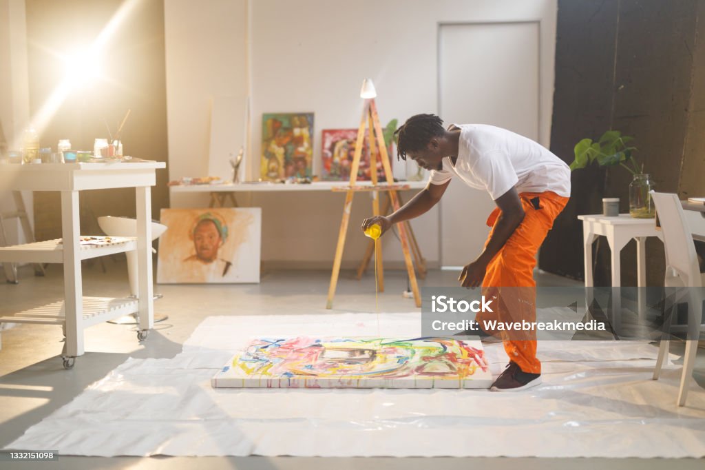 African american male painter at work painting on canvas in art studio African american male painter at work painting on canvas in art studio. creation and inspiration at an artists painting studio. Artist Stock Photo