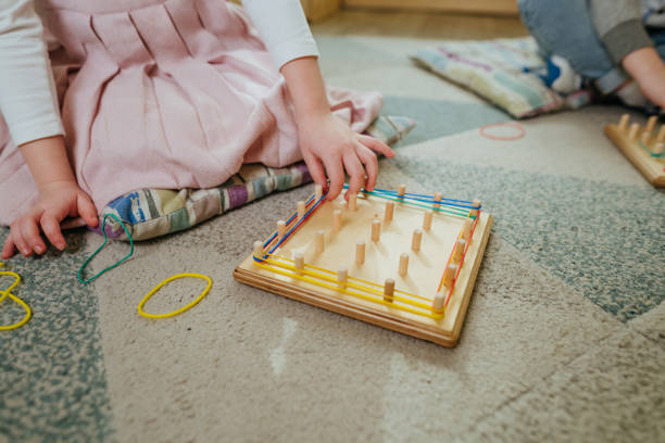 istock Preschool students playing with geoboard wrapping rubber bands in kindergarten 1332151789