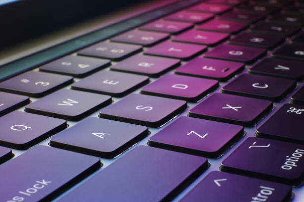 laptop/notebook keyboard with colorful background closeup of keyboard with puple and colorful background, technology and information computer keyboard stock pictures, royalty-free photos & images