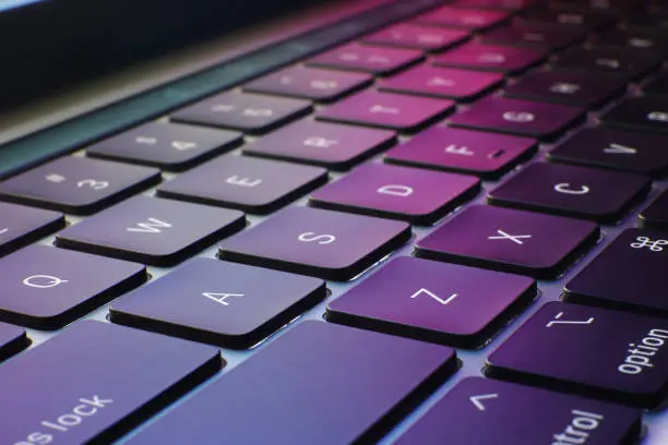 closeup of keyboard with puple and colorful background, technology and information