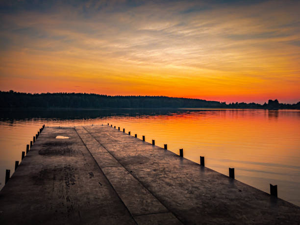 istock Sunset at lake, sky with clouds in background and pier in foreground 1332153935
