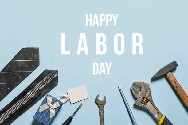 Happy Labor Day on bright blue background with various tools and ties. Labor Day. Construction tools with ties and gift box