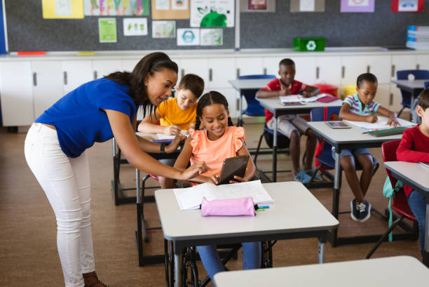 istock African american female teacher teaching disabled girl to use digital tablet at elementary school 1332155334