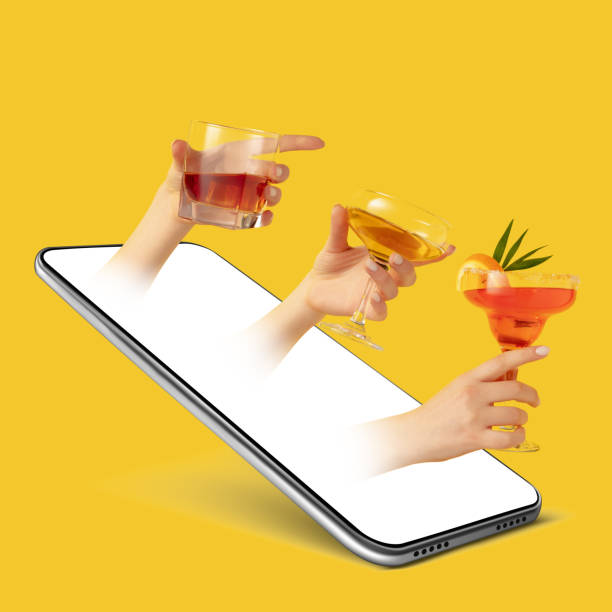 istock Creative collage. Hands with alcohol drinks sticking out of the smartphone screen over yellow background. 1332155575