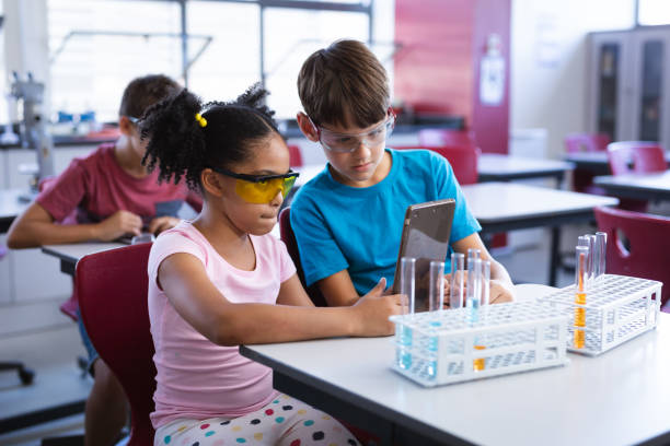 istock African american girl and caucasian boy using digital tablet in science class at elementary school 1332157259