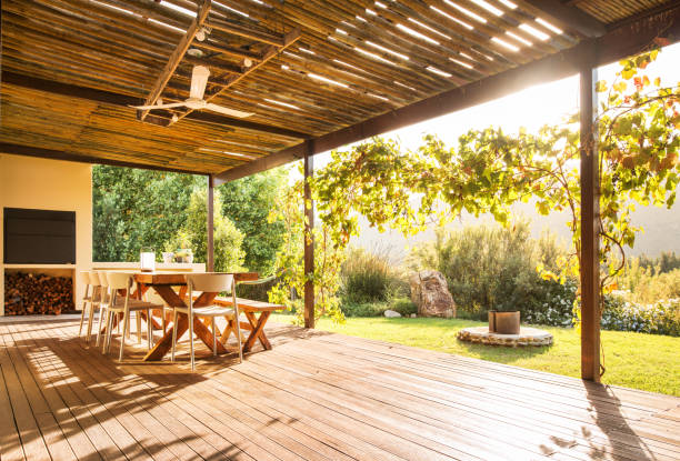 tisch und stühle auf einer rustikalen terrasse an einem sonnigen nachmittag - hausgarten stock-fotos und bilder