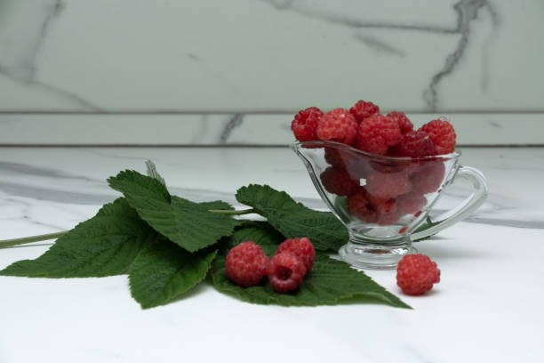 istock A glass cup with ripe raspberries on the kitchen table. 1332158474