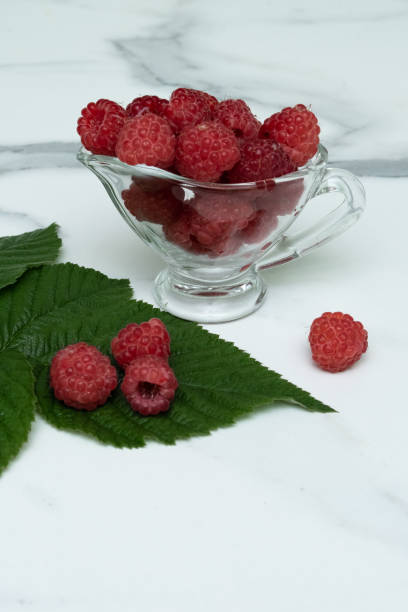 istock A glass cup with ripe raspberries on the kitchen table. 1332158481