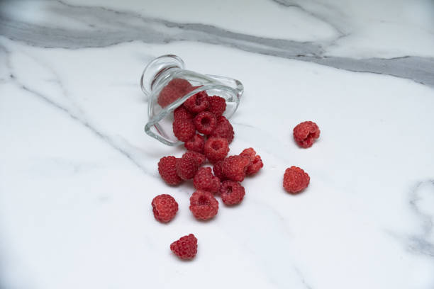 istock A glass cup with ripe raspberries on the kitchen table. 1332158531