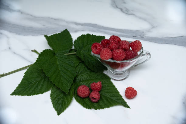 istock A glass cup with ripe raspberries on the kitchen table. 1332160109