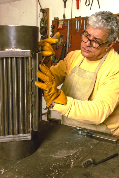 istock Older man working in his smithy, building handicrafts 1332161291