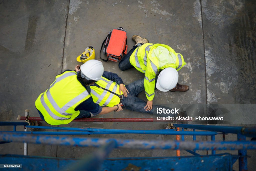 Safety team help employee accident falling scaffolding to the floor. Builder injury accident falling scaffolding to the floor. Basic first aid training for support accident in site work, Safety team help employee accident. Misfortune Stock Photo