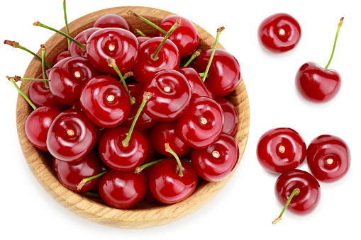 red cherry in wooden bowl isolated on white background. clipping path. top view