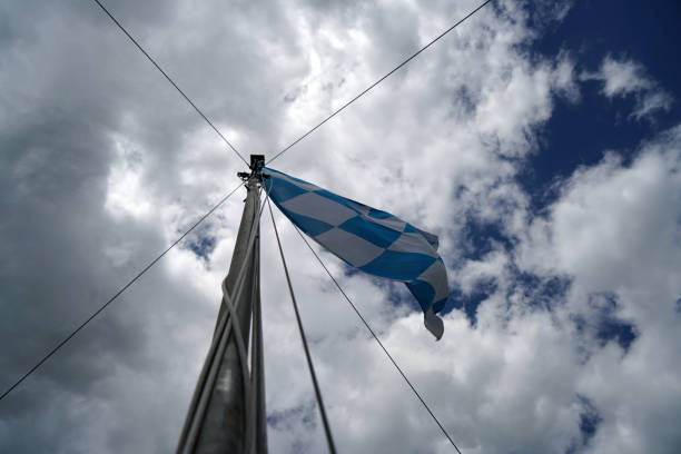 istock Bavarian flag flies against a blue white sky on a summer day in Bavaria 1332169708