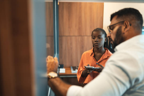 istock Side view of People writing down finances on transparent board 1332170868