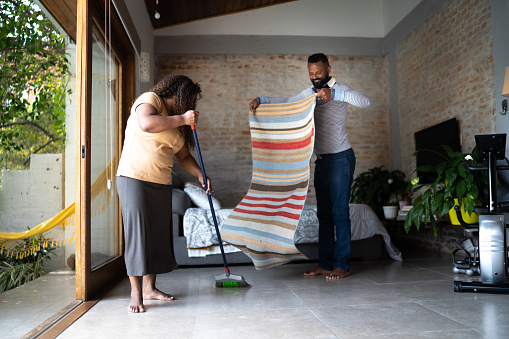 Mature couple cleaning house together