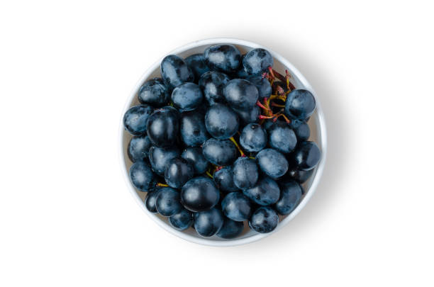 istock Black Grapes. Ripe berries in a white plate. Isolated on white. 1332175065