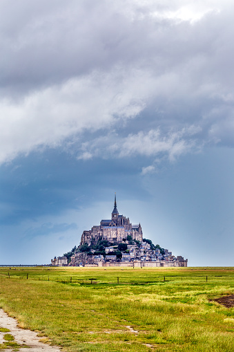 Mont Saint Michel, Normandy: Mont Saint Michel with green fields on a rainy day in the summer