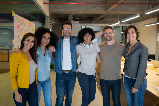 istock Happy group of coworkers smiling at a creative office 1332176333