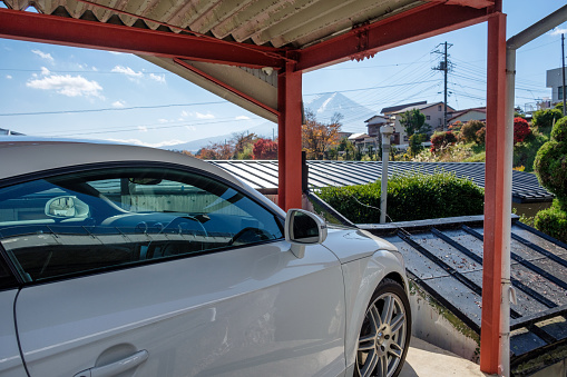 Yamanashi, Japan - Nov 10 2017 : White modern sport car parked inside open garage and view Fuji-san mountain in autumn