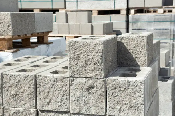 Photo of Stack of cement concrete Building cinder blocks brick  on pallete in hardware store with decorative stone texture side