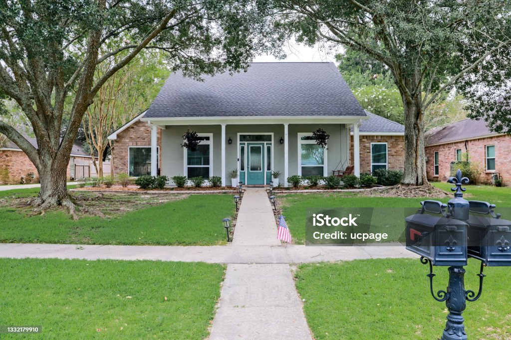 Eine Frontansicht eines akadischen renovierten Hauses mit Säulen, Bürgersteigen und einer farbenfrohen Haustür, die kürzlich mit dem sich verändernden Immobilienmarkt gekauft wurde - Lizenzfrei Wohnhaus Stock-Foto
