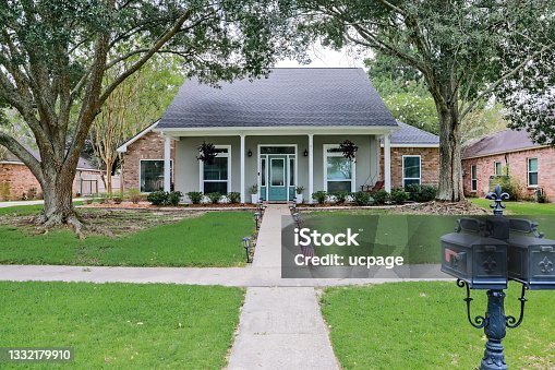 istock A front view of an Acadian renovated home with columns, sidewalks and a colorful front door recently purchased with the changing real estate market 1332179910