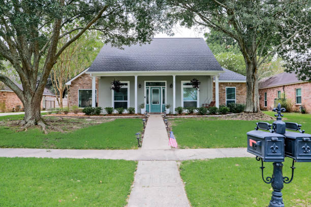 A front view of an Acadian renovated home with columns, sidewalks and a colorful front door recently purchased with the changing real estate market A front view of an Acadian renovated home with columns, sidewalks and a colorful front door recently purchased with the changing real estate market. reform photos stock pictures, royalty-free photos & images