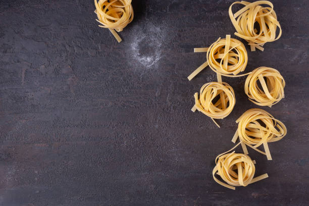 istock Tagliatelle pasta on a brown textured stone. 1332184228