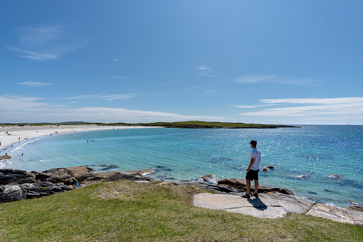 Traveler man admiring breathtaking scenery on Dogs bay beach in Galway Ireland