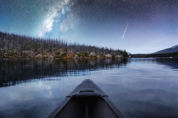 istock Canoeing with milky way and shooting star reflection on Maligne lake 1332188397