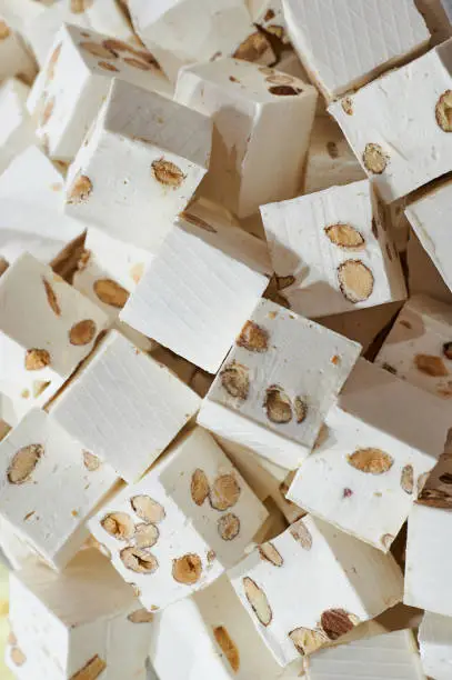 macro photo of white nougat in a French sweets shop, vertical color picture as background