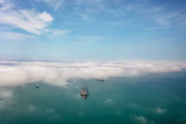 Photo of Container ship in transit under clouds.
