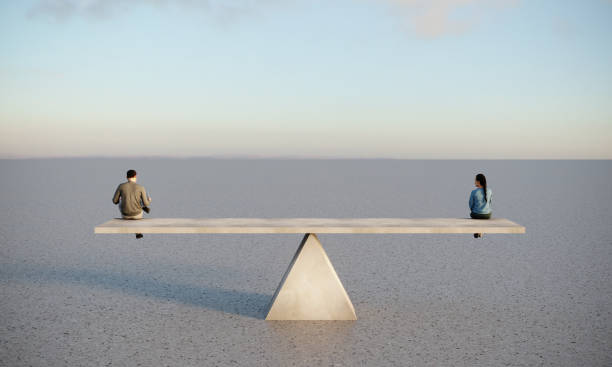 Gender Equality Concept Man and woman are sitting on concrete seesaw, symbolizing gender equality. (3d render) gender equality stock pictures, royalty-free photos & images