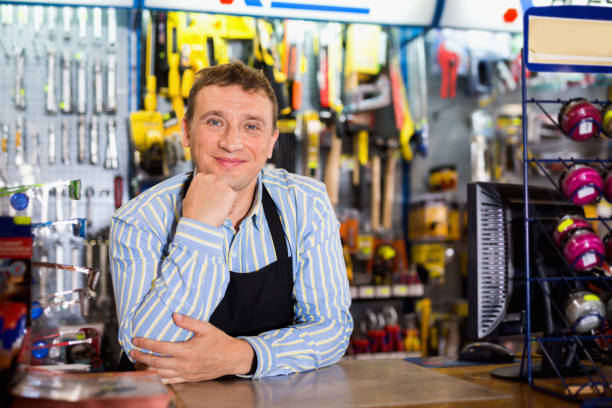 istock Man seller wearing uniform having tools in hands in store 1332194265