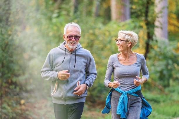 istock Smiling senior couple jogging in the park 1332194290