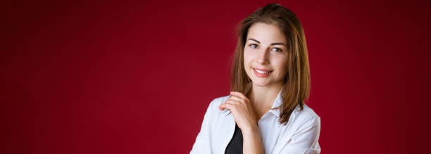istock A woman is standing and smiling against a red studio background 1332195295