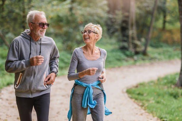 istock Smiling senior couple jogging in the park 1332196791