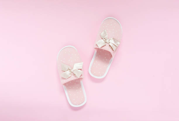 istock Pink home slippers on a pastel pink background. Top view. 1332196913