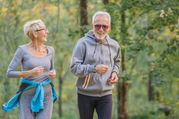 istock Smiling senior couple jogging in the park 1332196926